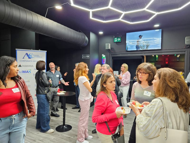 Real corporate event at Club X Indoor Golf, Aurora — networking night with cocktails, backdrop, and hex-lit ceiling