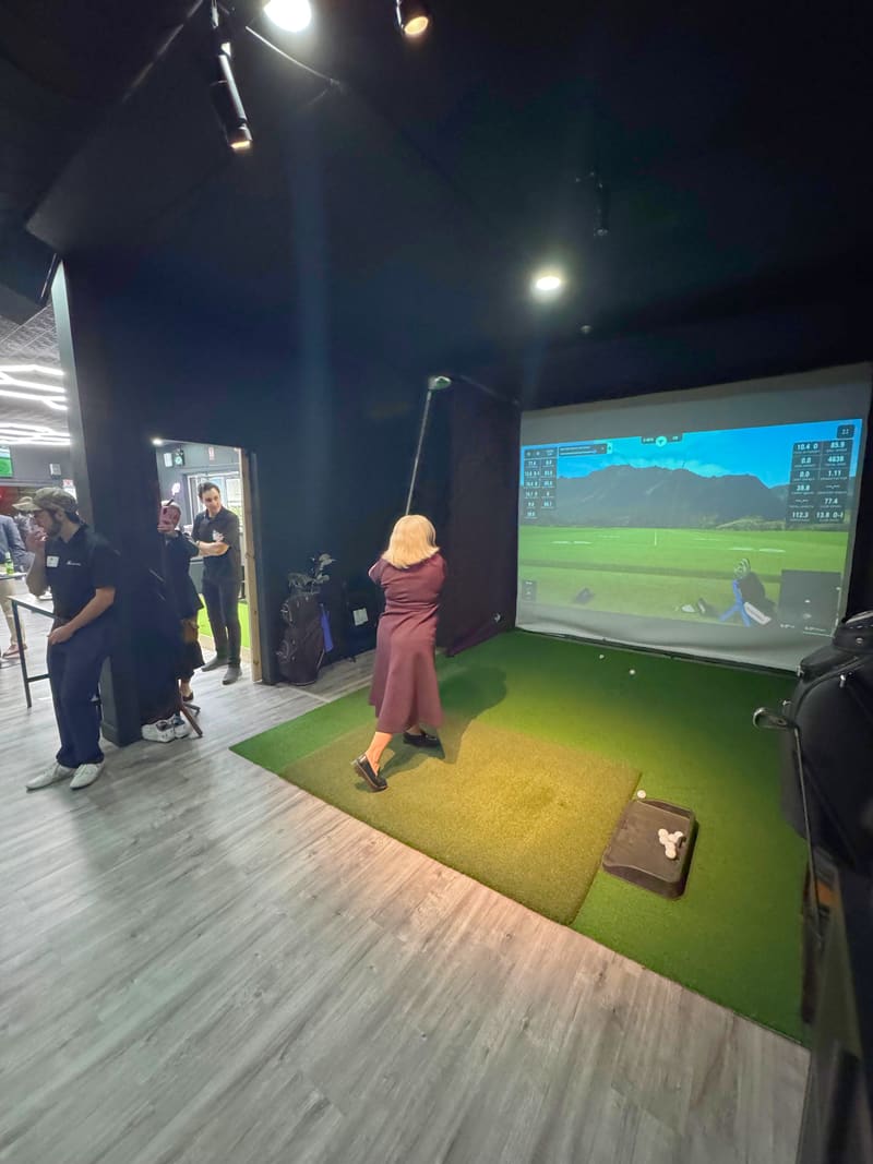 Student golfer practicing indoors at Club X Indoor Golf in Aurora with simulator data on screen
